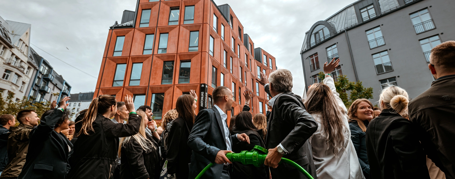 Group of employees gathered outdoors in front of office buildings during a team activity in an urban setting.